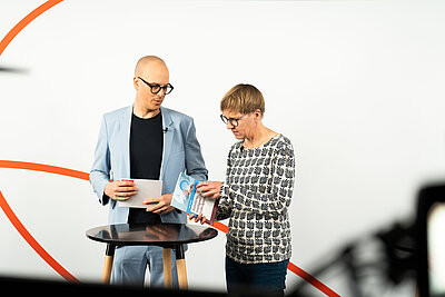 Eva Wolfangel beim Ansehen eines Buches zusammen mit Dr. Benjamin Wessinger