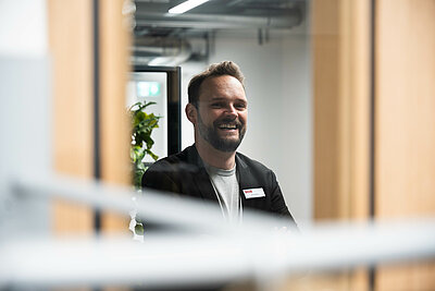 Backstage: Blick durchs Fenster, Jan Schüle schaut lachend in die Kamera
