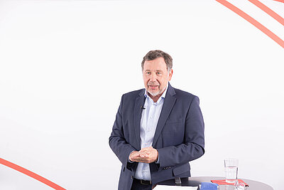 Dr. Markus Rohner steht referierend hinter einem Stehtisch.